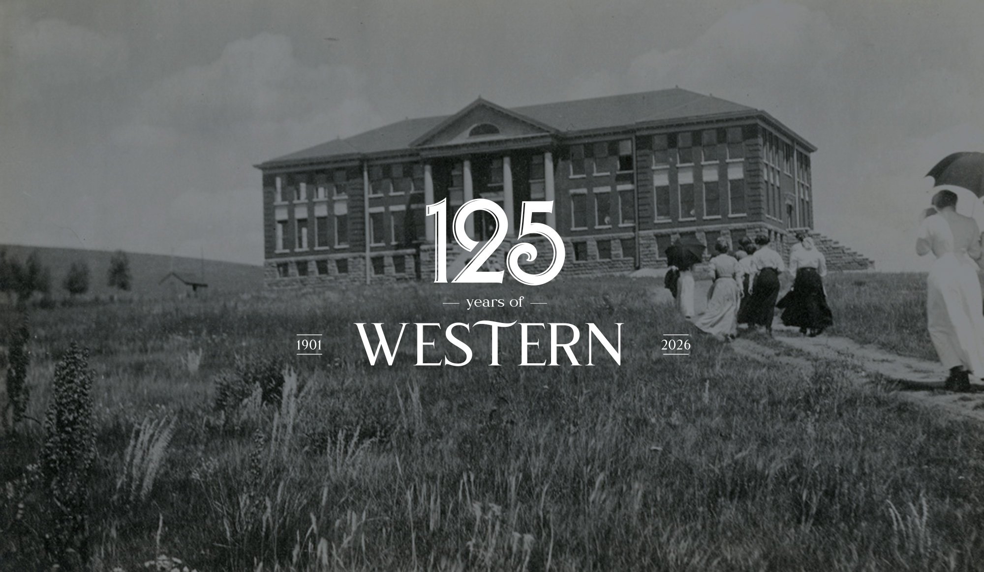 Members of the 1911 student body march up a dirt path through the weeds to Taylor Hall.