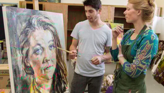 Tina Butterfield, assistant professor of art, discusses a painting with senior Silas McDonough in the painting studio of Quigley Hall.