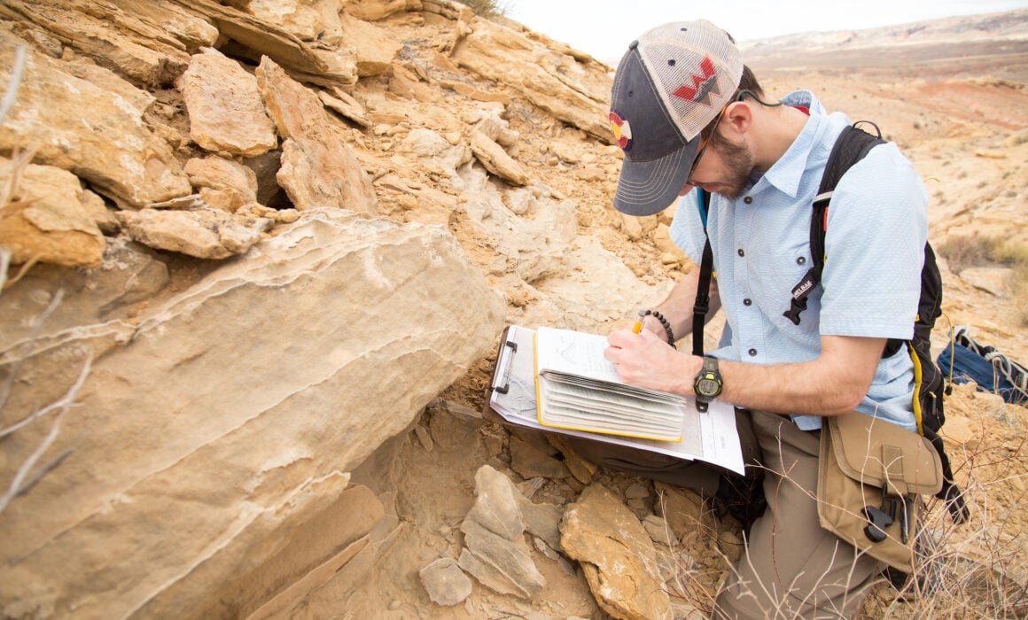 Nathan Hayman takes notes in the field.