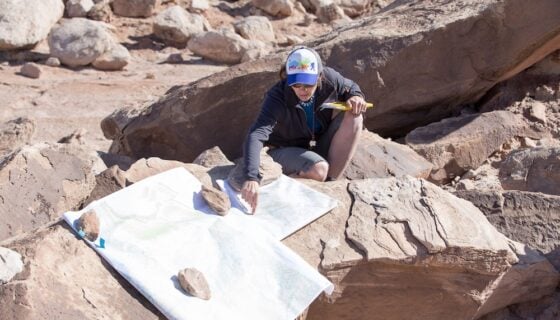 Dr. Petrie points something out on a map.