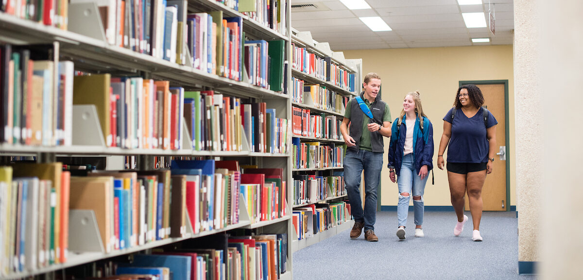 A group of students walking through the library together.