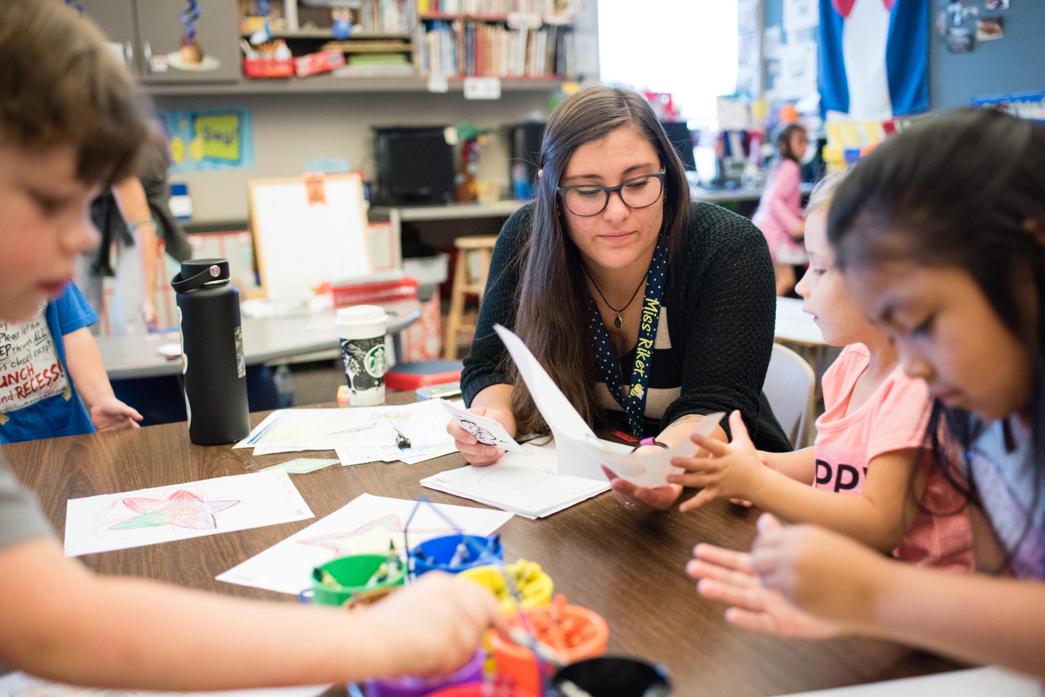 Student teacher, Alyeska Riker, helping a classroom of kindergarteners with their class work.