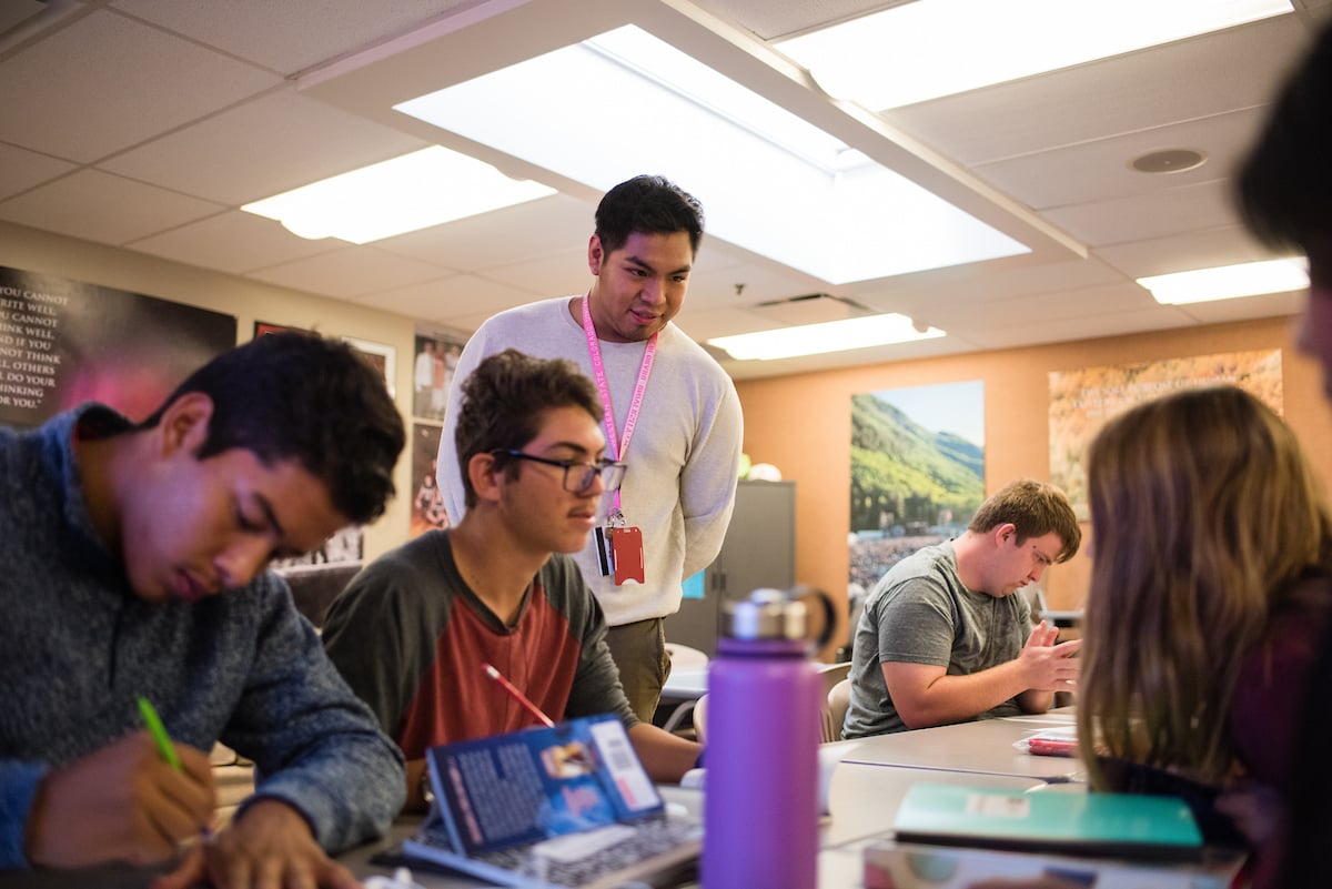 Student teacher, Cristian Aguilar, helping students with their class work.