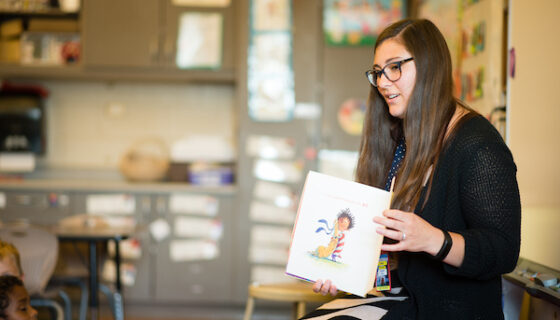Student teacher, Alyeska Riker, reading a book to a classroom of kindergarteners.