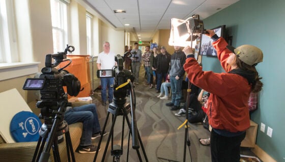 Student Carley Donk adjusts a lighting fixture during a film class.