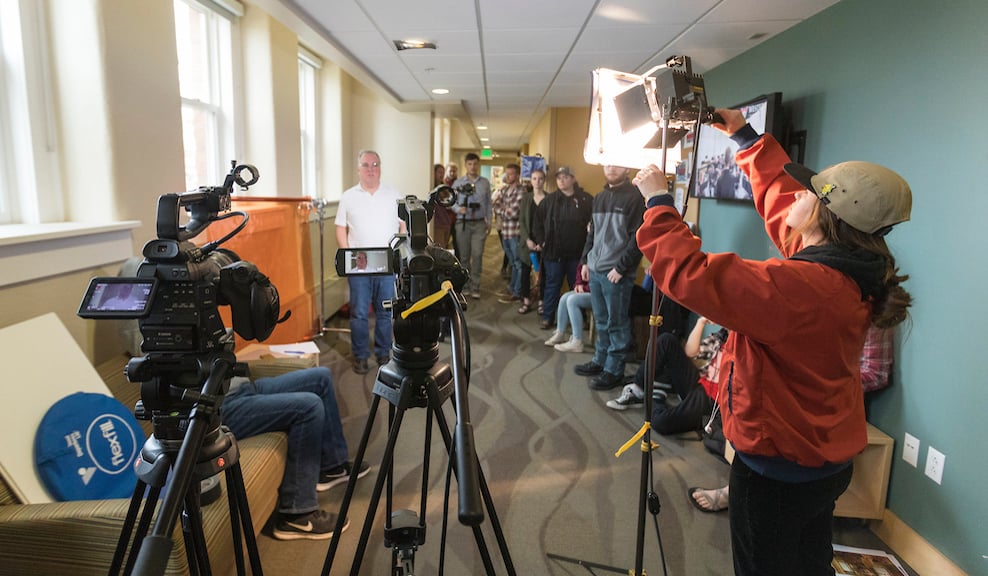 Student Carley Donk adjusts a lighting fixture during a film class.