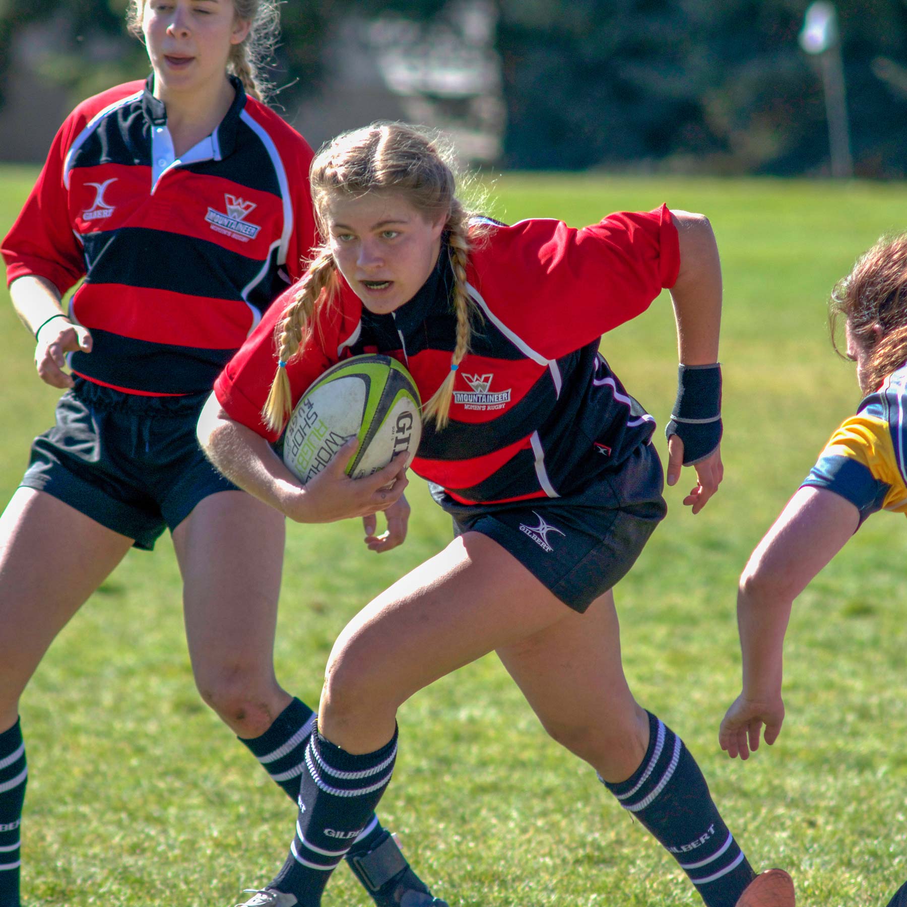 Women's rugby team playing a tough game.