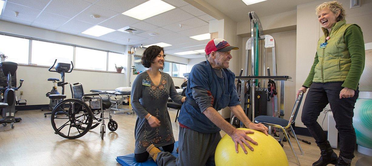 A Western graduate student guides a patient through a rehab exercise