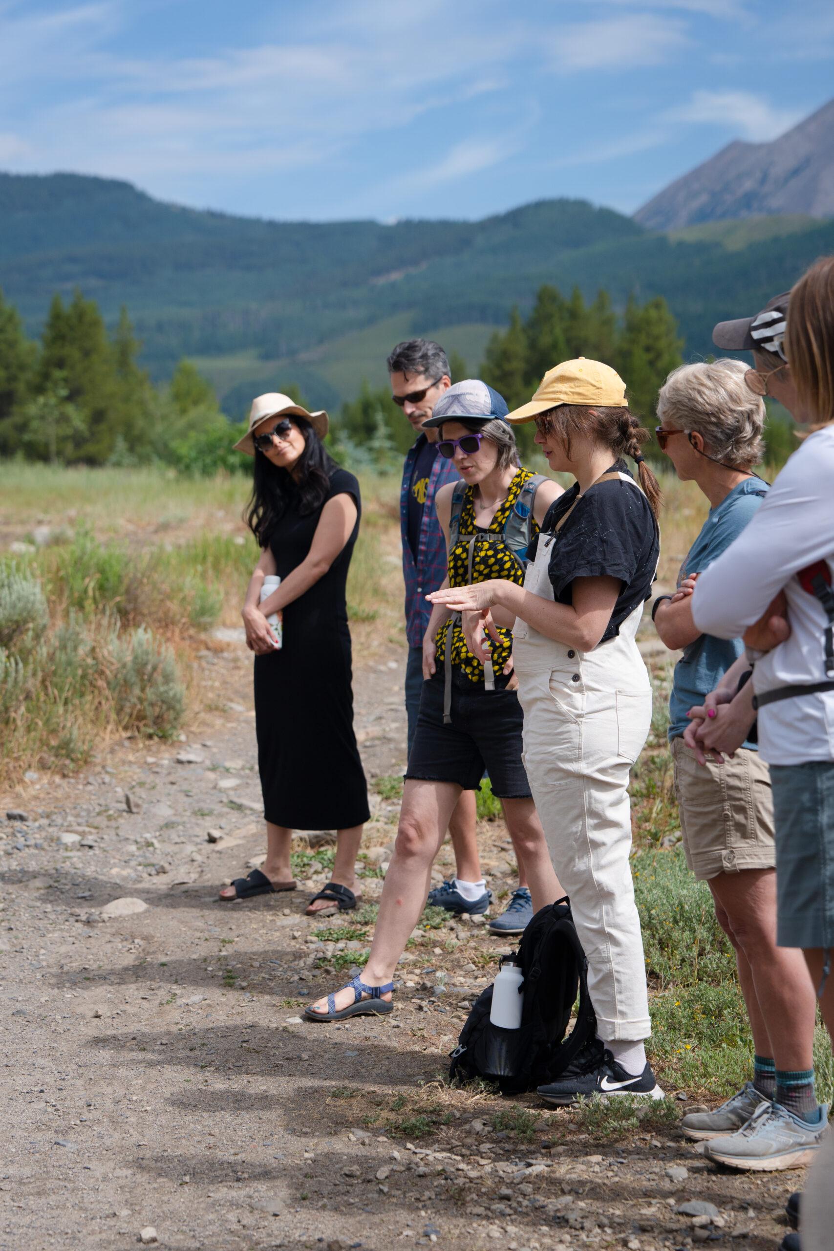 A grad student introduces themselves to the Nature Writing group as they all stand in a circle at the Lower Loop Trailhead.