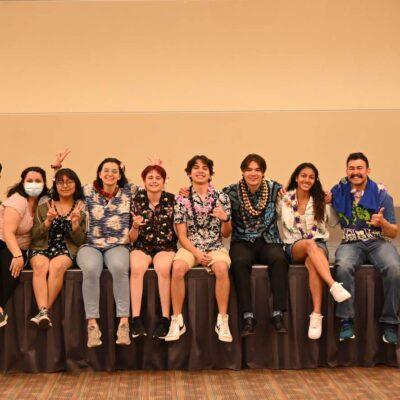 Members of the APIC club sit on a stage