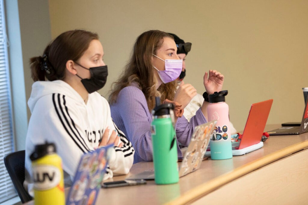 Several students listen to a lecture in a classroom