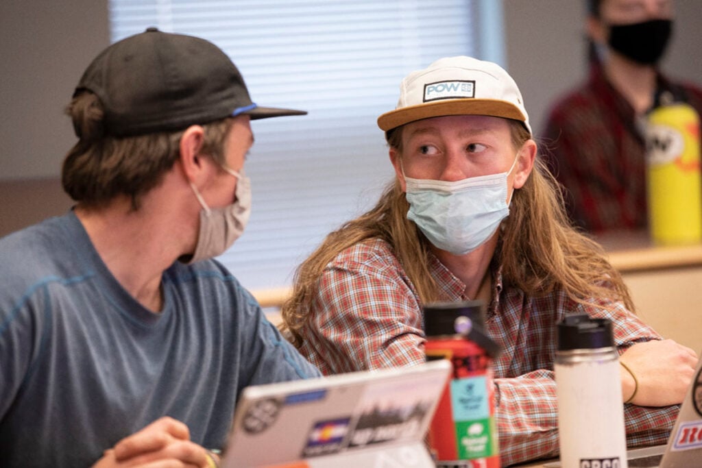 Two students talk together during a class