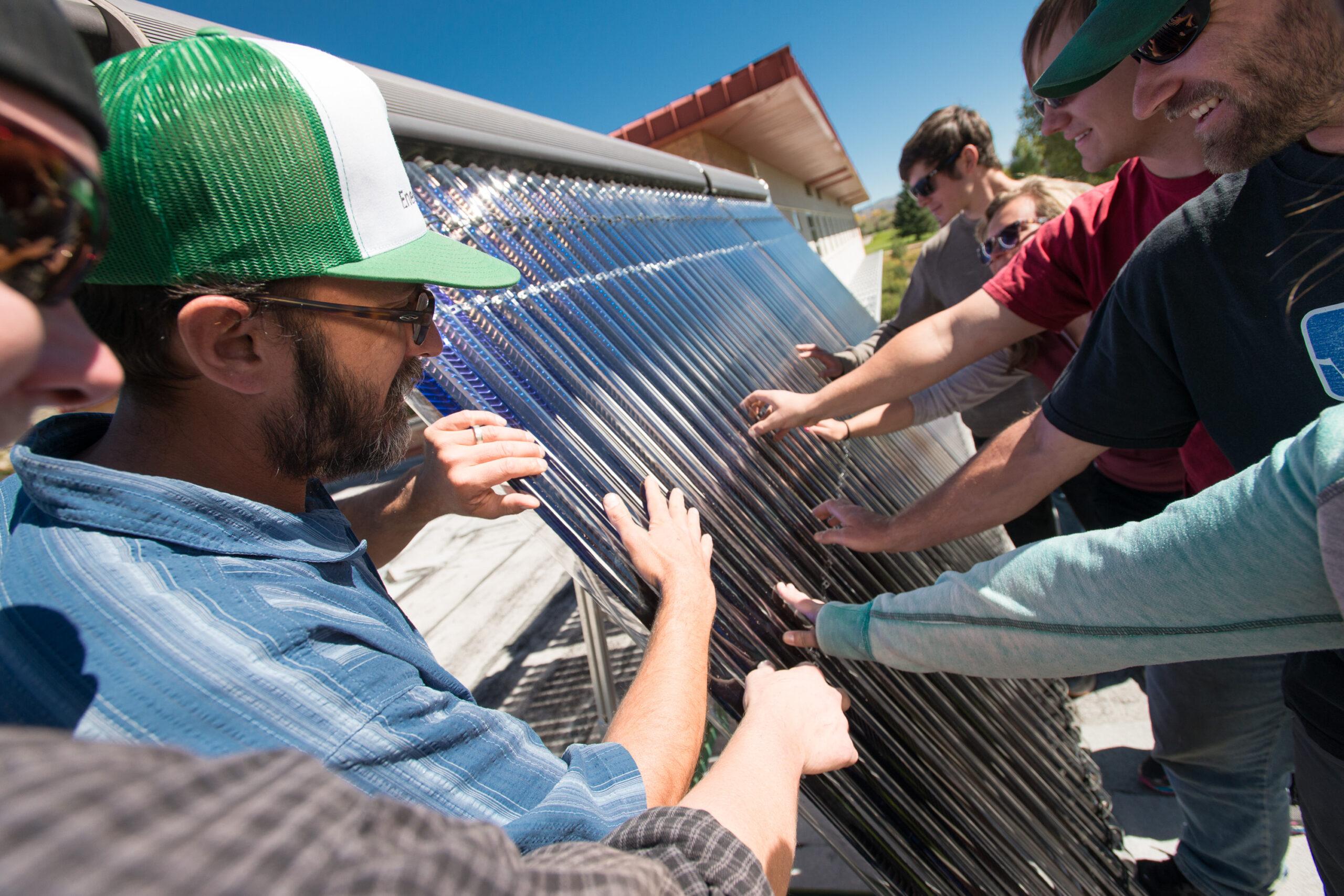 students listen to lecture on top of Kelley Hall about solar panels