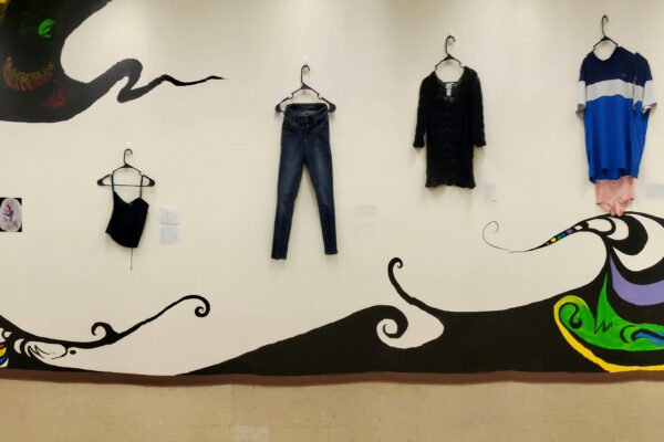 Various outfits hanging on gallery wall