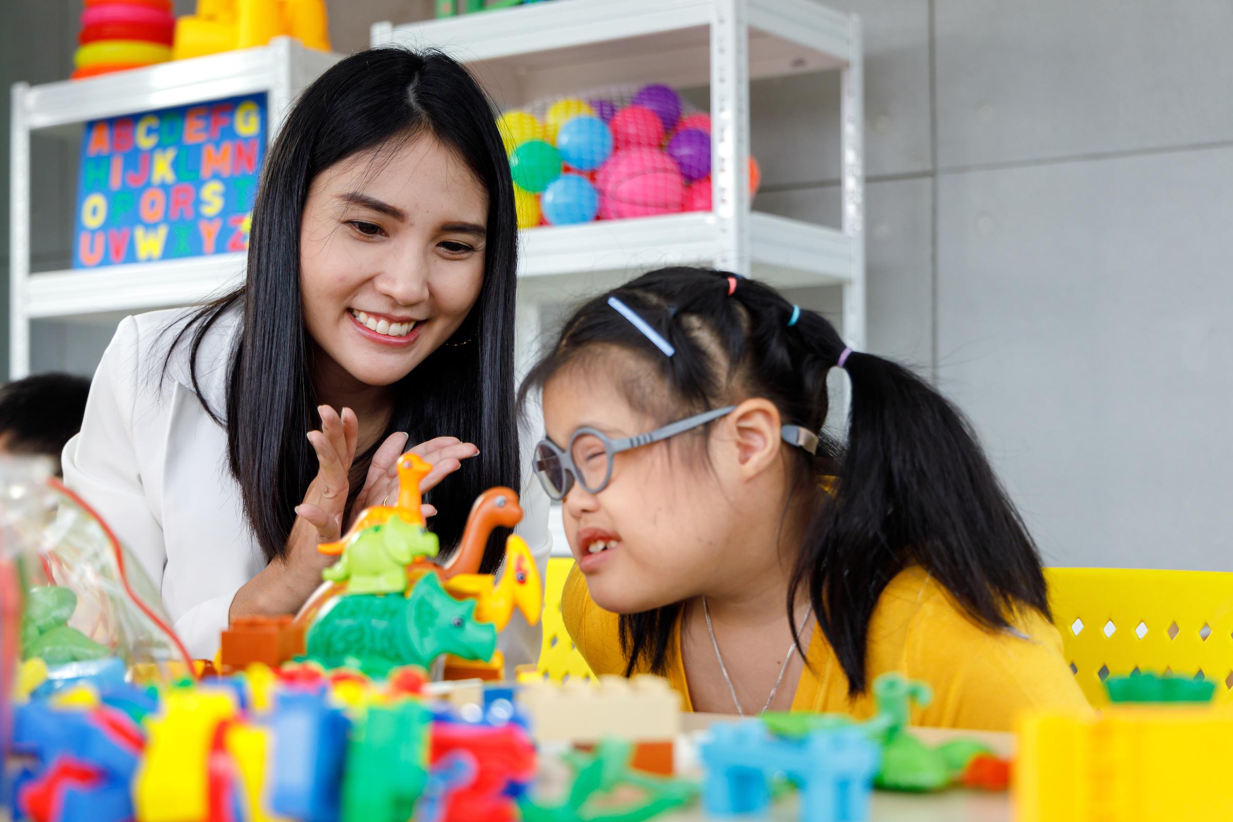 Teacher and child playing with toys