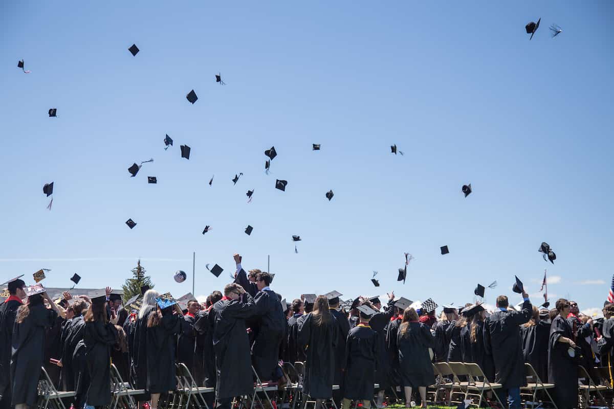 How to prepare for graduation: student throwing caps at graduation