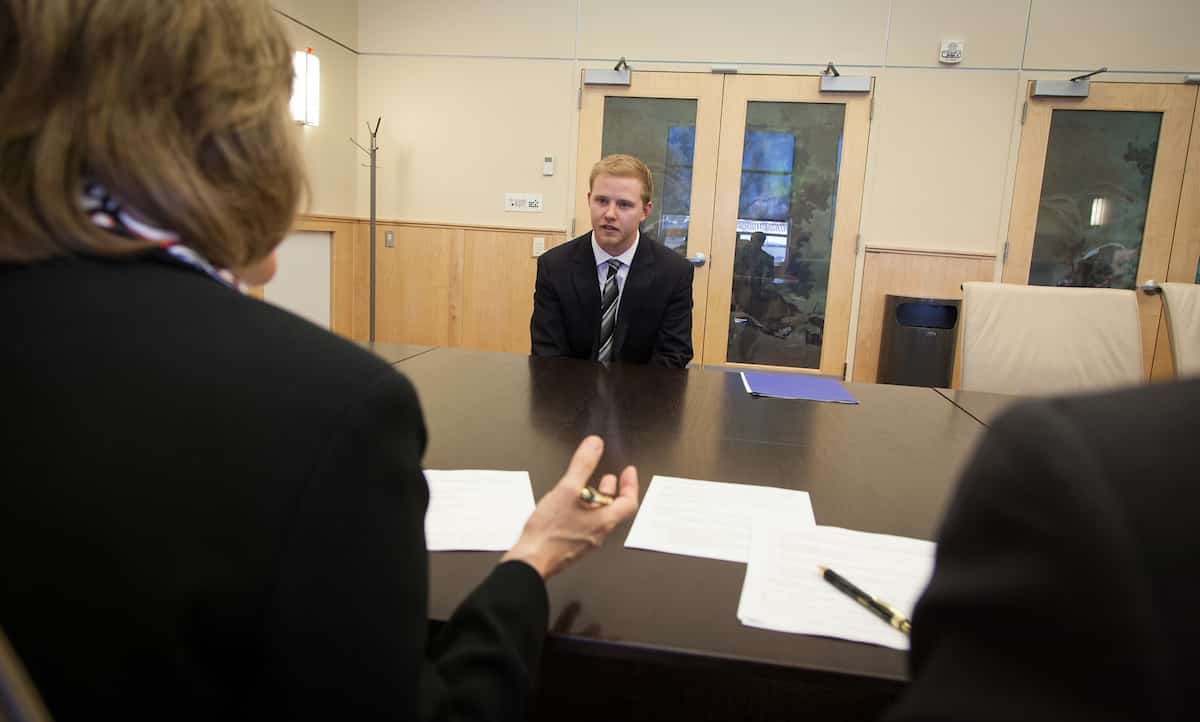 How to prepare for a graduate school interview: Student sitting across table from interviewers