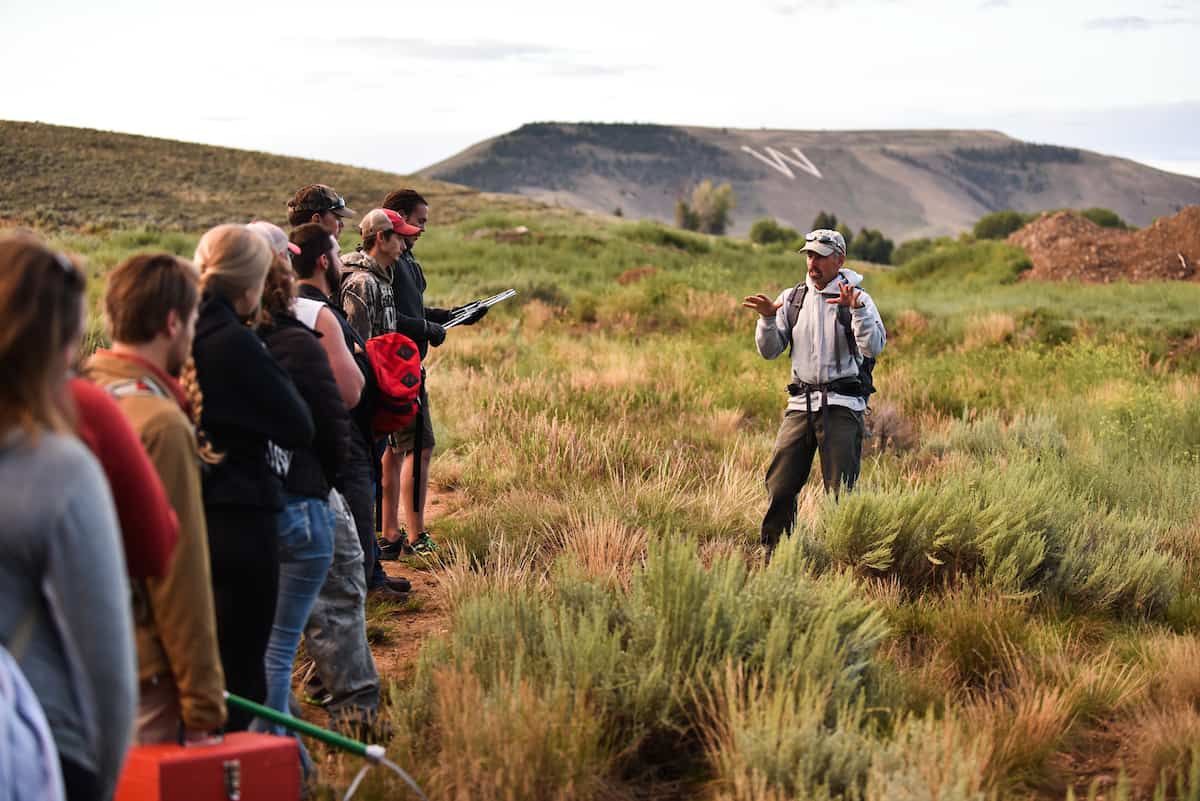 Outdoor college: professor leads lecture in group of students