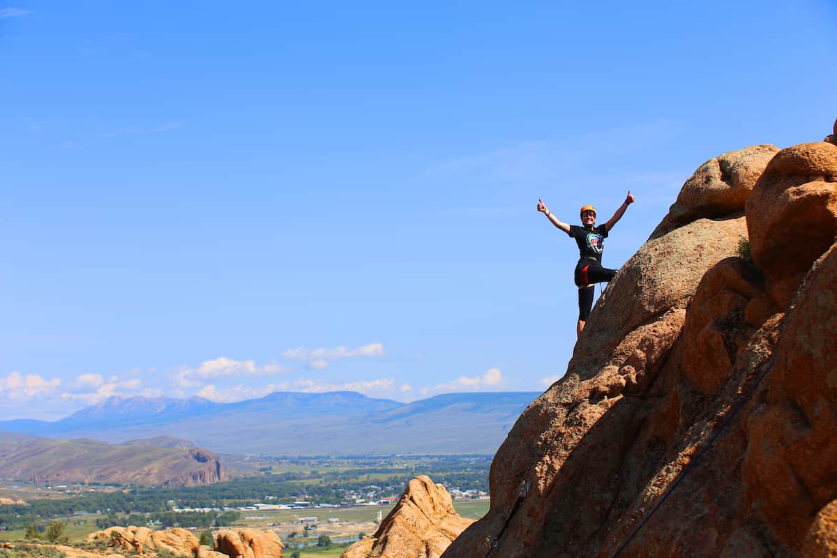 Colleges with rock climbing: student celebrates reaching the top of rock