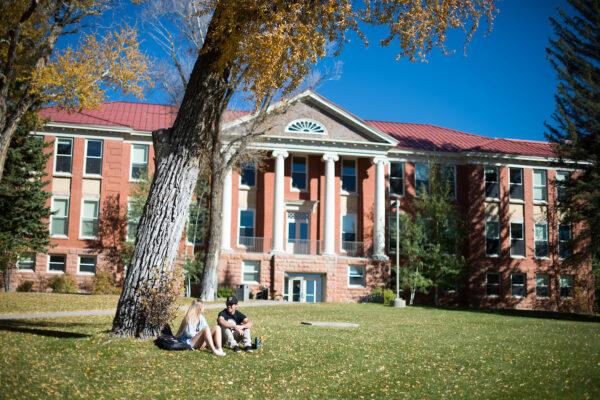 College open house: students sit outside Taylor Hall at Western Colorado University