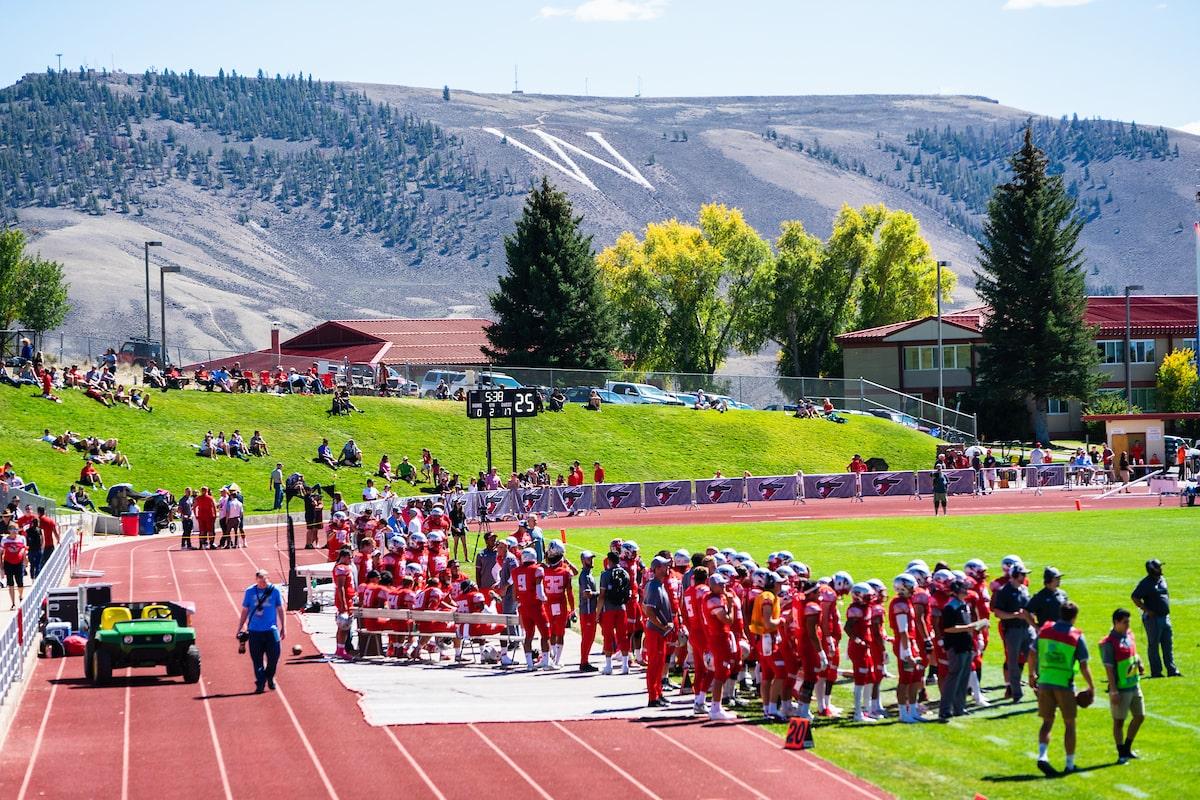 athletic training colleges: football players gathering on field