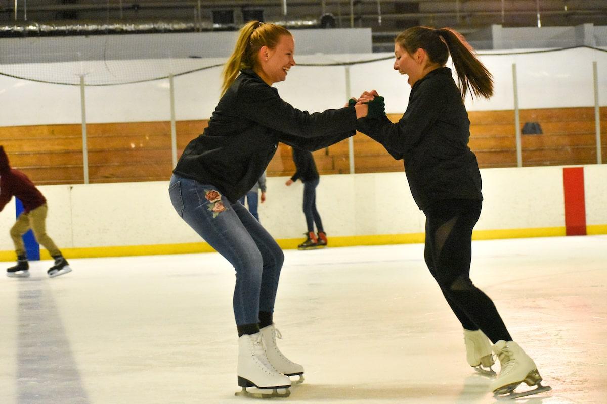 best colleges for club sports: ice skating students laughing together