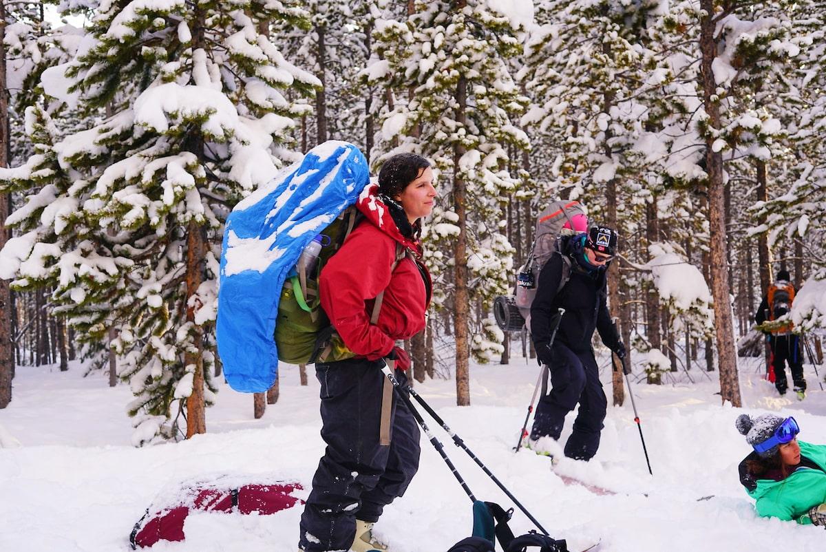 student with backpacking backpack hiking through the snow