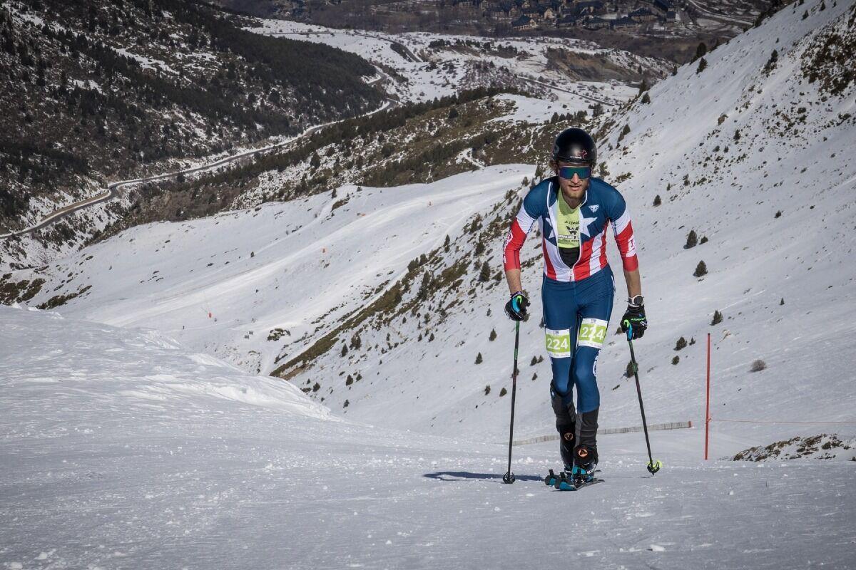 Western student athlete skiing up mountain