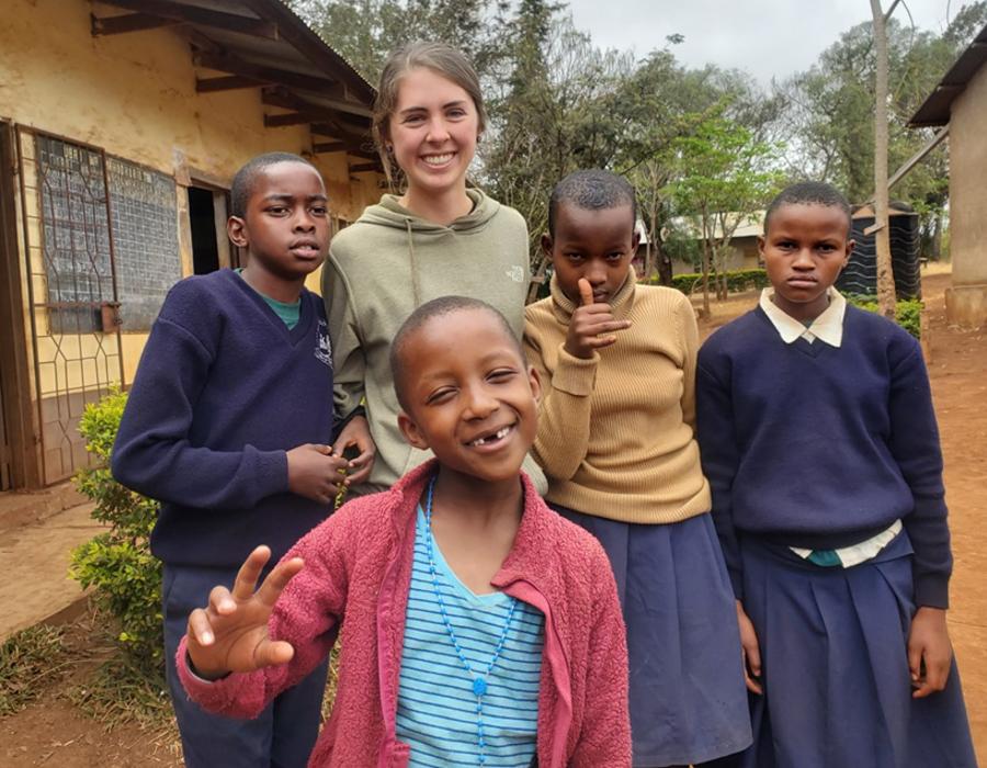 Student Alyssa Rawinski takes a photo with a group of children in an African village.