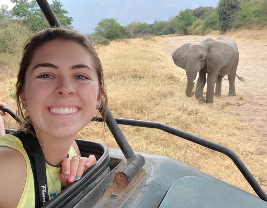 Student Alyssa Rawinski takes a selfie with an elephant in the background.