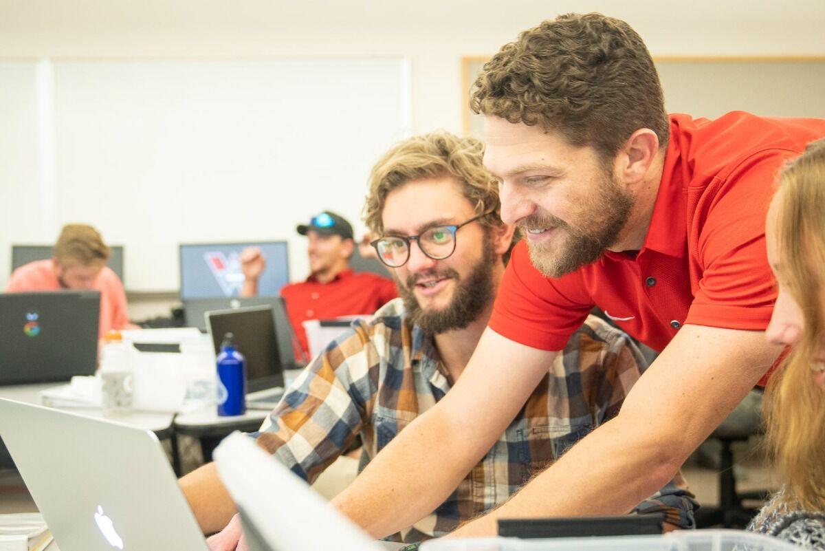 professor working with a student on a computer