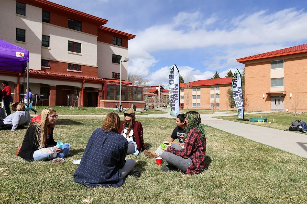 Students sitting on the ground talking at a zero waste event