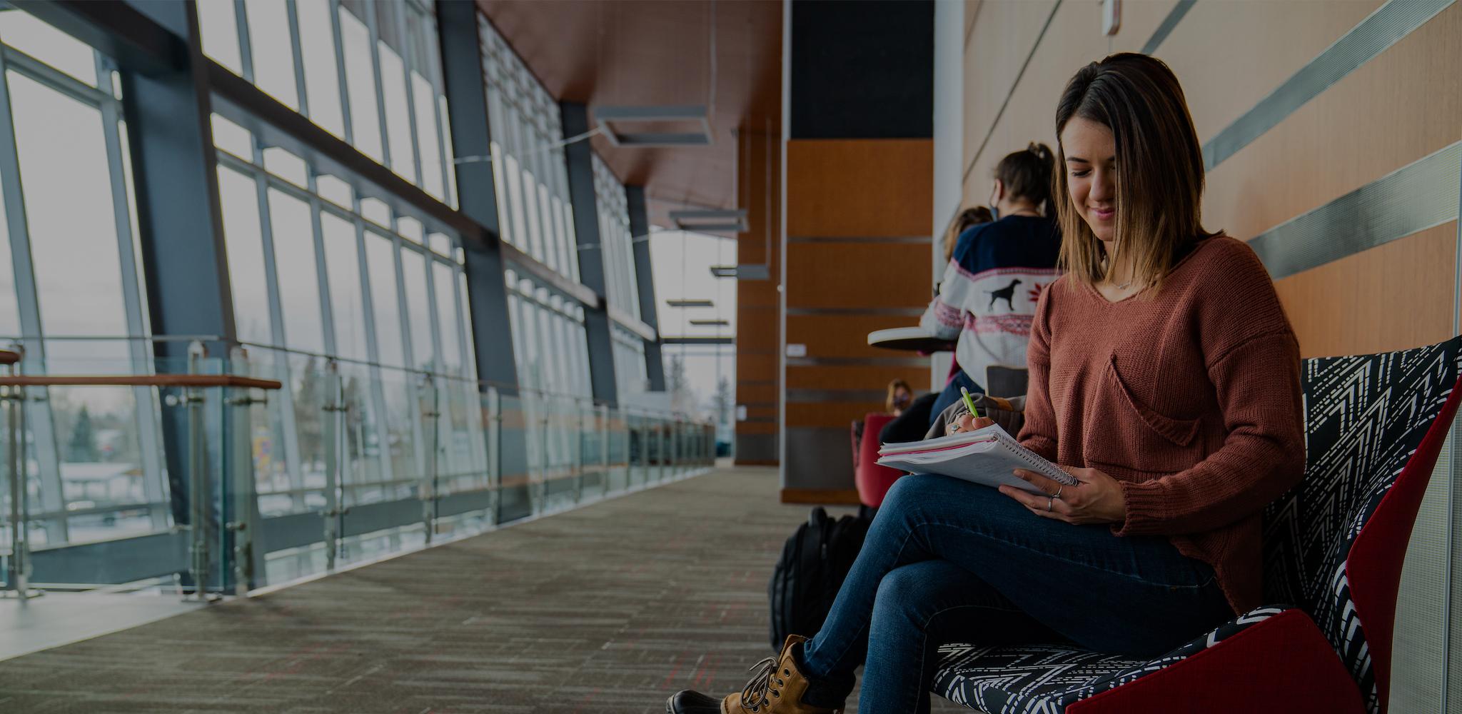 A student writes in a notebook