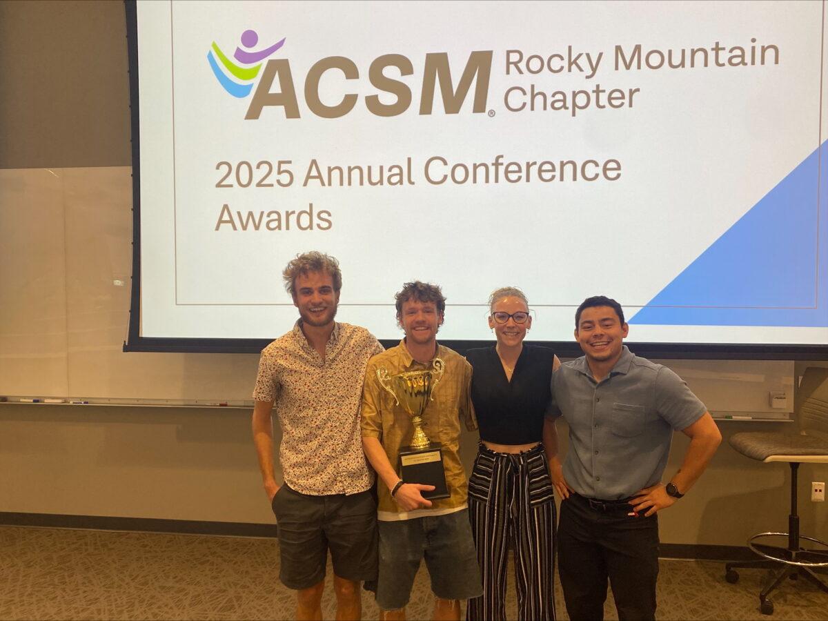 Students pose in front of their presentation at the ACSM conference.