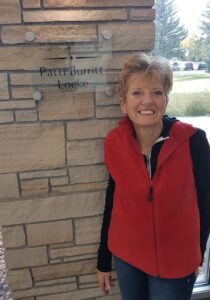 Patti poses with the sign commemorating her donation.