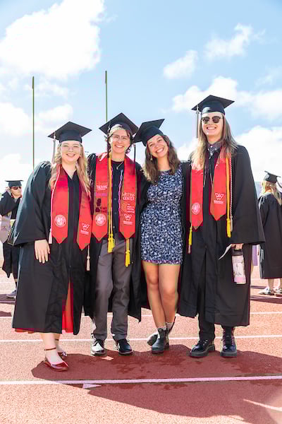 A group of students smiles for the camera at commencement 2025.