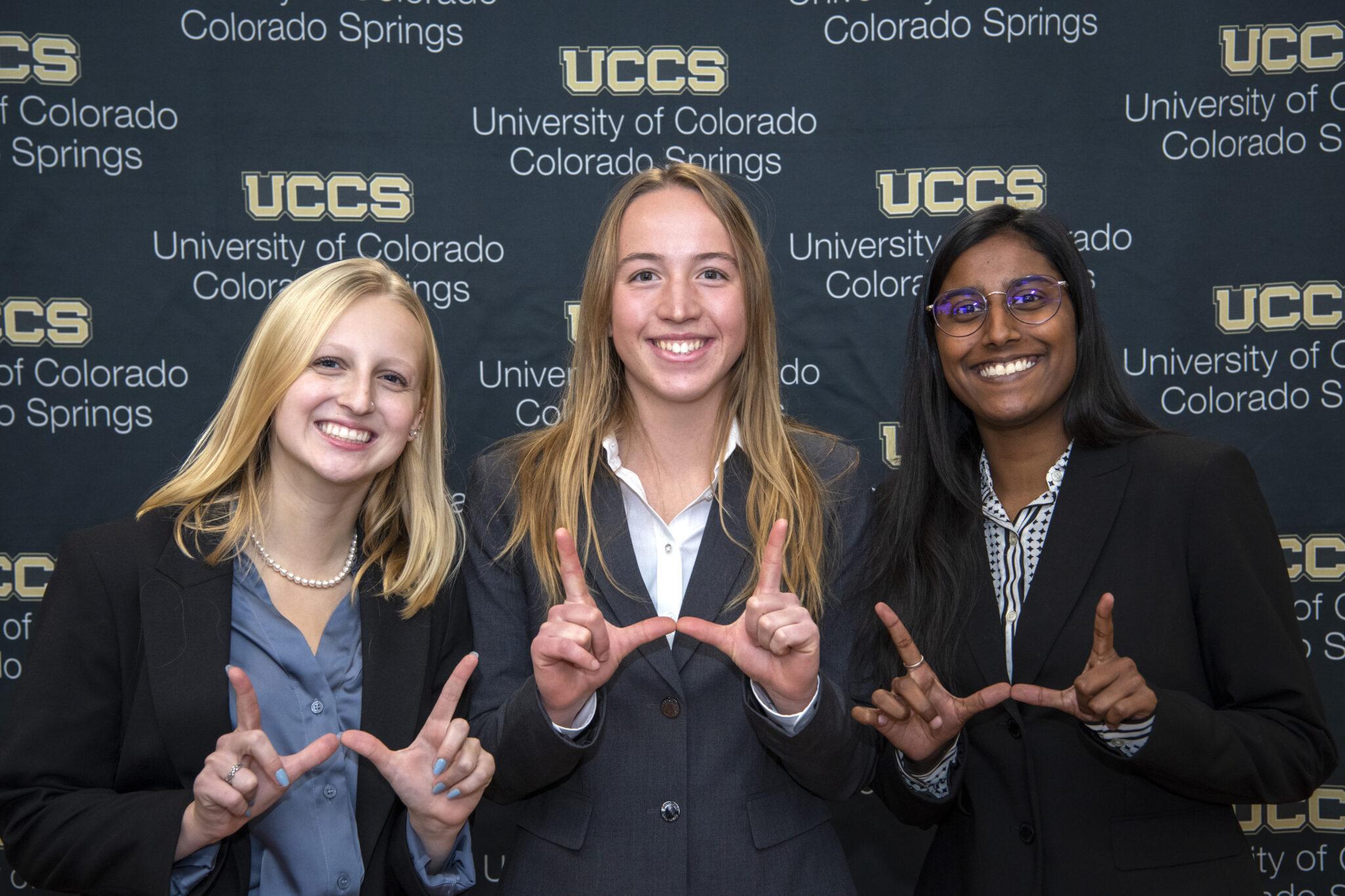 Three Western students pose with "W" hands