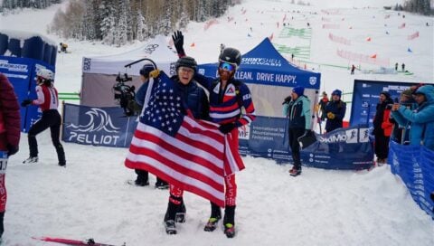 Cam Smith holds up the American flag at the Olympics.