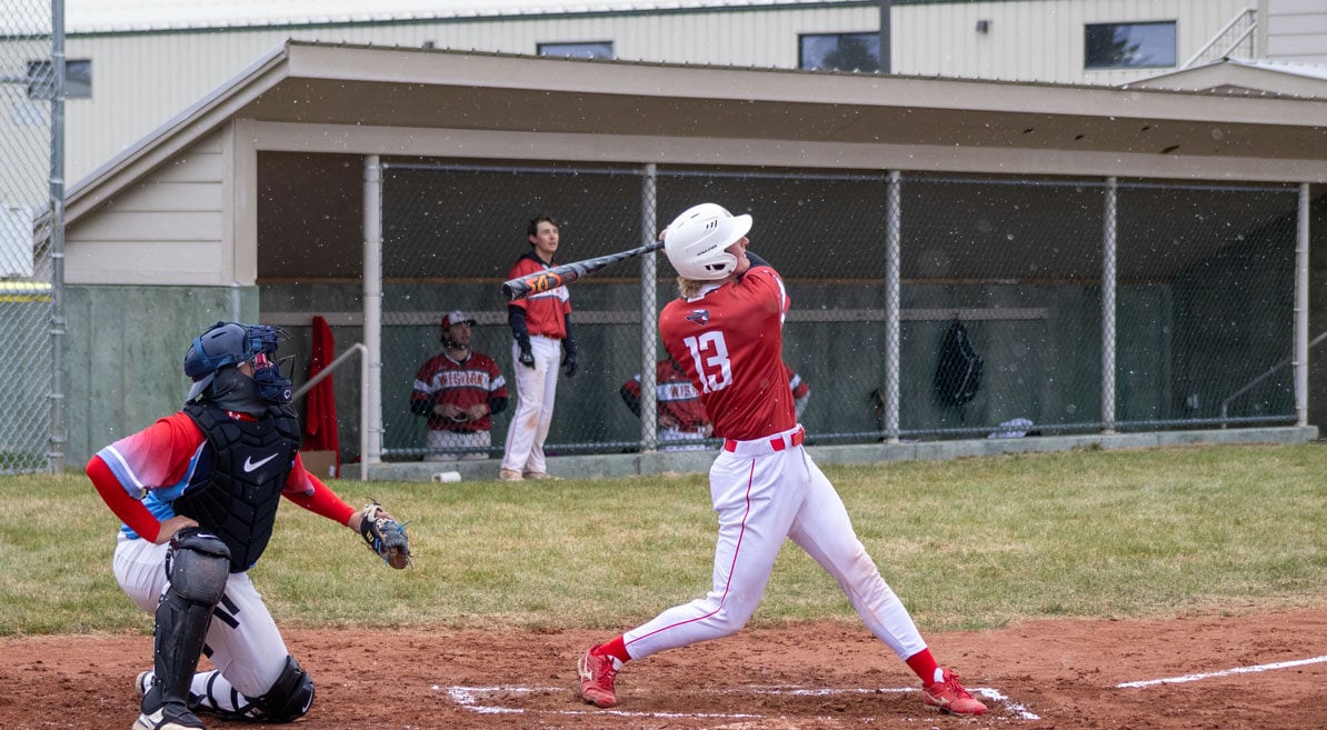 A baseball player swings a bat.