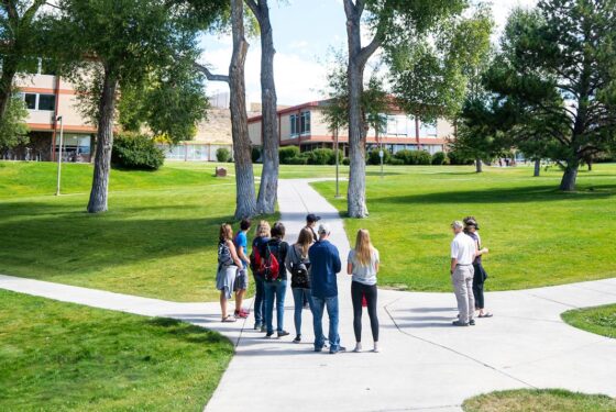 A group of several people attend a tour on Western Colorado University's campus.