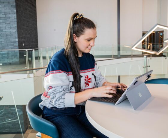 A student types on a laptop while studying at the Paul M. Rady School of Computer Science & Engineering.