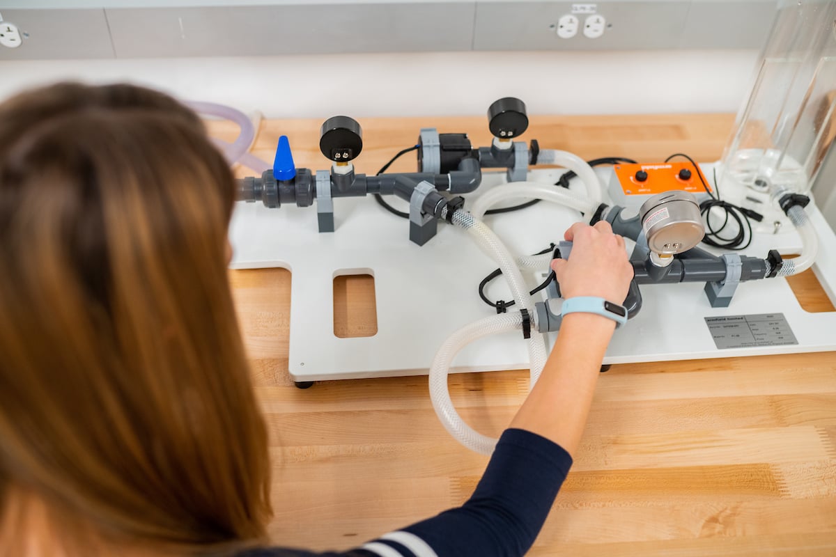 A student uses a piece of engineering equipment in a lab session