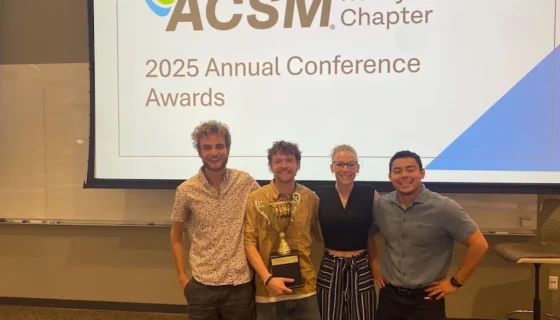 Students hold the trophy at the acsm conference.
