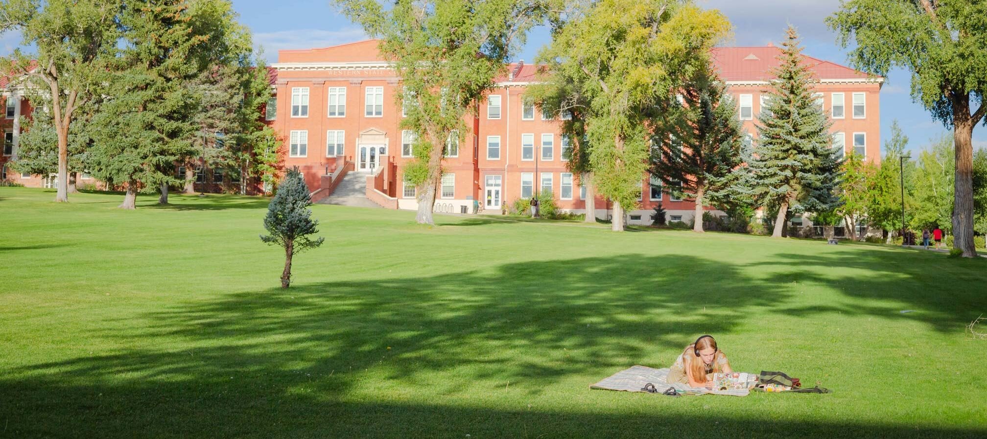 A student doing work on taylor lawn during a summer day.
