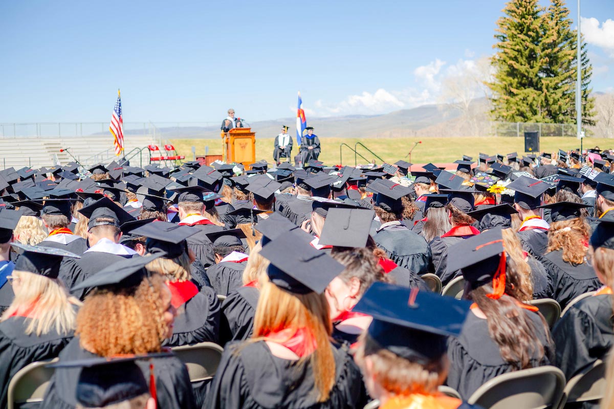 Students watch with their graduation caps the speaker.