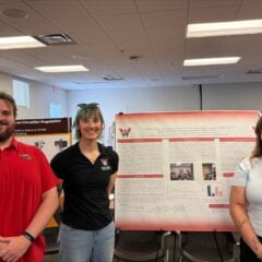 AESP students stand in front of their poster at the competition.