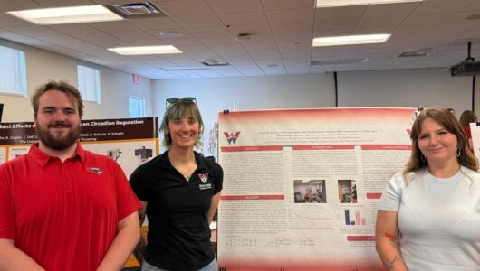 AESP students stand in front of their poster at the competition.