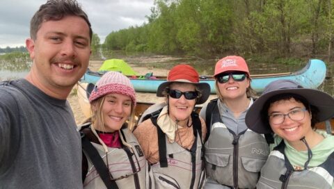 Western graduate students pose for a group shot on the Mississippi River.