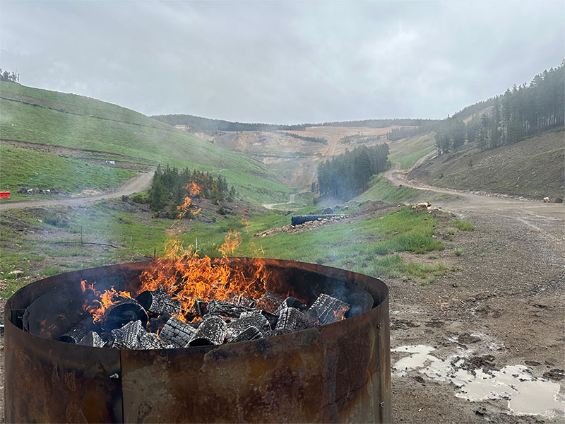 A biochar ring has wood on fire.