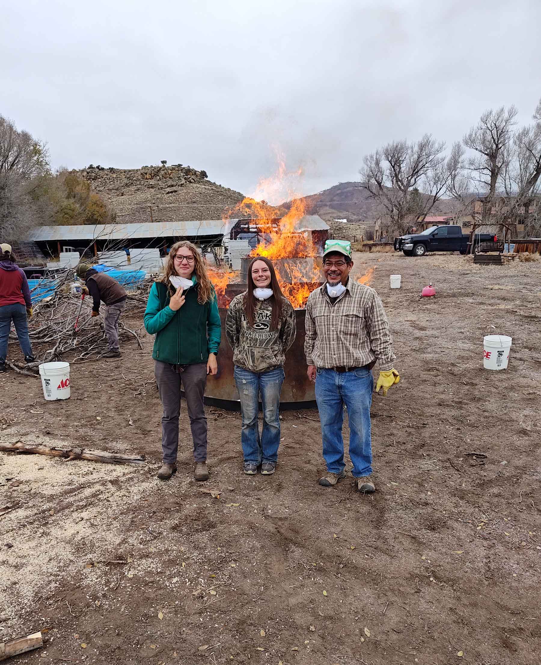 Students and Ricardo stand by the biochar.